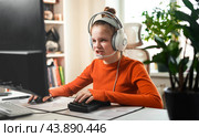 Teenage girl is sitting in a comfortable computer chair, playing a game on a PC. Стоковое фото, фотограф Енваев Андрей / Фотобанк Лори