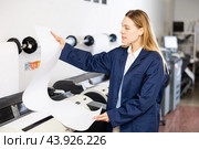 Print worker controlling printing process on modern offset machine in print shop. Стоковое фото, фотограф Яков Филимонов / Фотобанк Лори