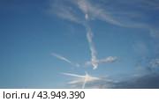 Plane leaves condensation trail. Chemtrail conspiracy theory. Long-lasting condensation trails left in sky by high-flying aircraft are actually chemtrails consisting of chemical or biological agents. Стоковое видео, видеограф Юлия Петровская / Фотобанк Лори