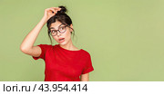 The girl with glasses remembered an old problem and thought about it. She keeps her hand on her head. Copy space. Стоковое AI-изображение, AI-художник Ярославский Максим / Фотобанк Лори