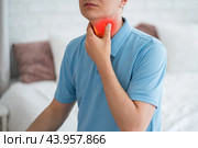 Thyroid gland inflammation, sore throat and cough, man with neck pain on gray background. Стоковое фото, фотограф Станислав Тарко / Фотобанк Лори