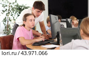 Guy teacher teaches girl student how to use computer. Стоковое видео, видеограф Яков Филимонов / Фотобанк Лори