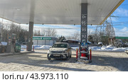 Moscow 08 February 2024, A taxi car at a gas station in the winter is refueled with gasoline. Редакционное фото, фотограф Скрипачев Антон / Фотобанк Лори
