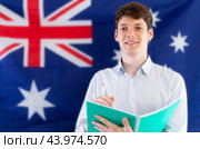 Young guy makes notes against background of flag of Australia. Стоковое фото, фотограф Татьяна Яцевич / Фотобанк Лори