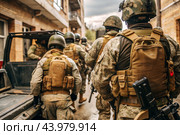 War. Military actions. Soldiers of the elite anti-terrorist unit of the army among the broken buildings. Clearing the territory from the enemy. Стоковое AI-изображение, AI-художник Photojuli / Фотобанк Лори