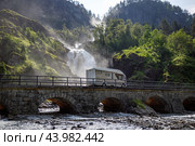 Holiday trip in motorhome, Caravan car Vacation. RV traveling on the road Latefossen Waterfall Odda Norway. Latefoss is a powerful, twin waterfall. Стоковое фото, фотограф Андрей Армягов / Фотобанк Лори