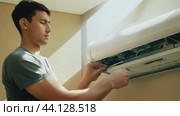 Technician repairing air conditioner indoor unit using screwdriver. Стоковое AI-видео, аниматор Данил Руденко / Фотобанк Лори