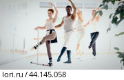 Rehearsal in ballet studio - group of people performing battement tendu at the ballet barre. Стоковое видео, видеограф Яков Филимонов / Фотобанк Лори