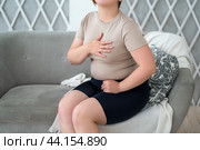 Heart attack, woman with chest pain suffering at home, myocardial infarction. Стоковое фото, фотограф Станислав Тарко / Фотобанк Лори