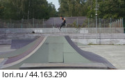 A boy rides a scooter in a skate park. Children's leisure. Moscow. Kuzminki. 17.08.2024. Редакционное видео, видеограф Ярославский Максим / Фотобанк Лори