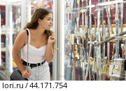 Interested young woman viewing various swords placed on display case. Стоковое фото, фотограф Яков Филимонов / Фотобанк Лори