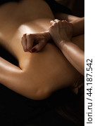 Woman masseur doing medical back backbone massage of lady patient close-up in dark medical spa office in shadow. Rehab massage, healthy relax massaging. Wellness, health concept. Copy ad text space. Стоковое фото, фотограф Aleksandr Golubev / Фотобанк Лори