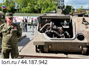 Российский военнослужащий возле разбитого американского бронетранспортера M113 A2. Выставка трофейной техники из зоны СВО. Город Тюмень (2024 год). Редакционное фото, фотограф Александр Тараканов / Фотобанк Лори