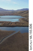 Vertical drone video of flying over a hilly rural landscape with a winding road and fish ponds. Altai Krai. Стоковое видео, видеограф Сергей Пристяжнюк (Serg Zastavkin) / Фотобанк Лори