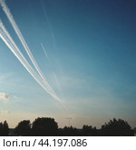 Chemtrail conspiracy theory. Long-lasting condensation trails left in sky by high-flying aircraft are actually chemtrails consisting of chemical or biological agents, sprayed for nefarious purposes. Стоковое AI-изображение, AI-художник Юлия Петровская / Фотобанк Лори