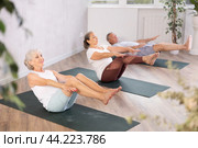 Senior woman performs boat asana - Paripurna navasana. Стоковое фото, фотограф Яков Филимонов / Фотобанк Лори