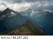 View of the Great Caucasian Ridge and the Upper station of the cable car system of the Dombay ski resort on a summer day, Karachay-Cherkessia, Russia. Стоковое фото, фотограф Ula Ulachka / Фотобанк Лори