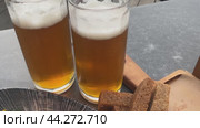 Two mugs with light beer and foam on the table. croutons for beer are lying nearby. Bubbles of cold beer in close-up. Стоковая анимация, аниматор Скрипачев Антон / Фотобанк Лори