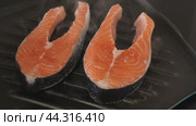 There are two pieces of broiled salmon steaks in square black frying pan. Стоковое видео, видеограф Яков Филимонов / Фотобанк Лори