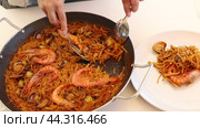 Hand holding spoon of seafood fideua. Стоковое видео, видеограф Яков Филимонов / Фотобанк Лори