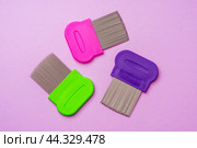 Three combs for removing lice and nits on lilac background. Стоковое фото, фотограф Сергей Толмачёв / Фотобанк Лори