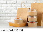 Take out food in boxes and craft bag against brick background. Стоковое фото, фотограф Сергей Толмачёв / Фотобанк Лори