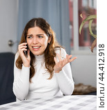 Wrathful woman quarreling on phone in apartment. Стоковое фото, фотограф Яков Филимонов / Фотобанк Лори