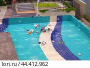 Pool repair. Workers lay new tiles on the bottom of the pool, Thailand, Pattaya (2024 год). Редакционное фото, фотограф Коханова Наталья / Фотобанк Лори