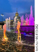 Illuminated night fountain with a view of the house with a spire in which Viktor Tsoi lived. Fountain at the Russian National Library, Victory Park metro station, St. Petersburg (2024 год). Стоковое фото, фотограф Регина Ерофеева / Фотобанк Лори