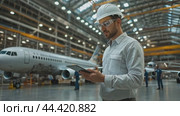Aviation engineer is holding a tablet and doing a pre-flight check. Стоковое AI-видео, аниматор Юрий Поздников / Фотобанк Лори