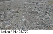 Bulldozer tractor pushes garbage from a mountain in a city dump. Стоковое видео, видеограф Игорь Соловьев / Фотобанк Лори