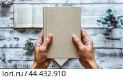 Макет обложки книги. Место для текста. Руки, держащие книгу, демонстрируют чистую обложку. Раскрытые книги располагаются на белом деревянном столе, создавая чистую и минималистичную эстетику. Стоковое AI-изображение, AI-художник Юлия Ильина / Фотобанк Лори
