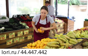 Positive saleswoman in apron offering oranges on the supermarket. Стоковое видео, видеограф Яков Филимонов / Фотобанк Лори