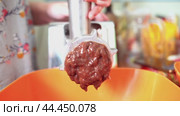 Close-up of twisted beef liver being extruded through a meat grinder, showcasing its texture and the transformation from solid to a processed form. Стоковое видео, видеограф Татьяна Степанищева / Фотобанк Лори