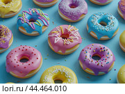 Colorful assorted donuts on blue background. Стоковое AI-изображение, AI-художник Иван Рябоконь / Фотобанк Лори