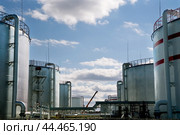 Нефтяные цистерны на фоне облачного неба. Стоковое фото, фотограф Павел Просянов / Фотобанк Лори