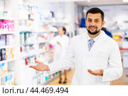 Portrait of positive druggist making presenting gesture. Стоковое фото, фотограф Яков Филимонов / Фотобанк Лори