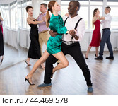 Woman dances incendiary tango with African man partner during choreography lesson. Стоковое фото, фотограф Яков Филимонов / Фотобанк Лори