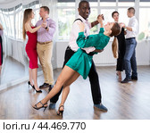 Woman dances incendiary tango with African man partner during choreography lesson. Стоковое фото, фотограф Яков Филимонов / Фотобанк Лори