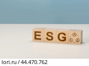 ESG Environmental, social, and governance concept of environmental, social and governance. Sustainable corporation development. Wooden cubes with ESG standing with other ESG icons. Copy space. Стоковое фото, фотограф Павел Муравьев / Фотобанк Лори