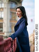 Portrait close-up of beautiful intelligent brunette who walks down street of St. Petersburg in city center. Charming thoughtful woman with long dark hair wanders alone, immersed in thoughts. Стоковое фото, фотограф Natalia Gdovskaia / Фотобанк Лори
