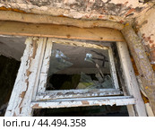 Broken window of an abandoned building with peeling paint. Стоковое фото, фотограф Антон Гвоздиков / Фотобанк Лори