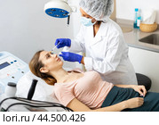 Woman cosmetician giving face injections of botulinum toxin for young woman. Стоковое фото, фотограф Яков Филимонов / Фотобанк Лори