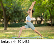 Woman practicing yoga in garden, performing Anjaneyasana, or Crescent Moon Pose. Стоковое фото, фотограф Яков Филимонов / Фотобанк Лори