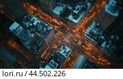 Aerial view of a bustling New York City intersection surrounded by illuminated skyscrapers at night. Стоковое AI-изображение, AI-художник Сергей Толмачёв / Фотобанк Лори