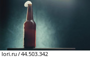 Opening a bottle of refreshing beverage in a dimly lit setting with atmospheric smoke. Стоковое видео, видеограф Сергей Толмачёв / Фотобанк Лори