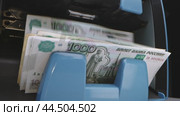 Counting cash at a bank ATM while depositing one thousand rubles in Moscow during peak afternoon hours. Стоковое видео, видеограф Сергей Толмачёв / Фотобанк Лори