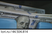 A close-up of a hundred dollar bill being deposited into a machine. Стоковое видео, видеограф Сергей Толмачёв / Фотобанк Лори