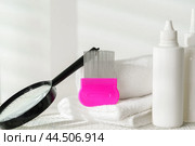 Lice treatment product next to a nit comb and magnifying glass. Стоковое фото, фотограф Сергей Толмачёв / Фотобанк Лори