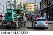 Автовышка Tadano  в центре Москвы  на Театральной площади остановлена патрульным автомобилем. Водитель вышки вышел из машины и отвечает на вопросы гаишника.(2024)/ A Tadano aerial platform in the center of Moscow on Teatralnaya Square was stopped by a patrol car for violating traffic rules. Редакционное фото, фотограф Iva Noel / Фотобанк Лори